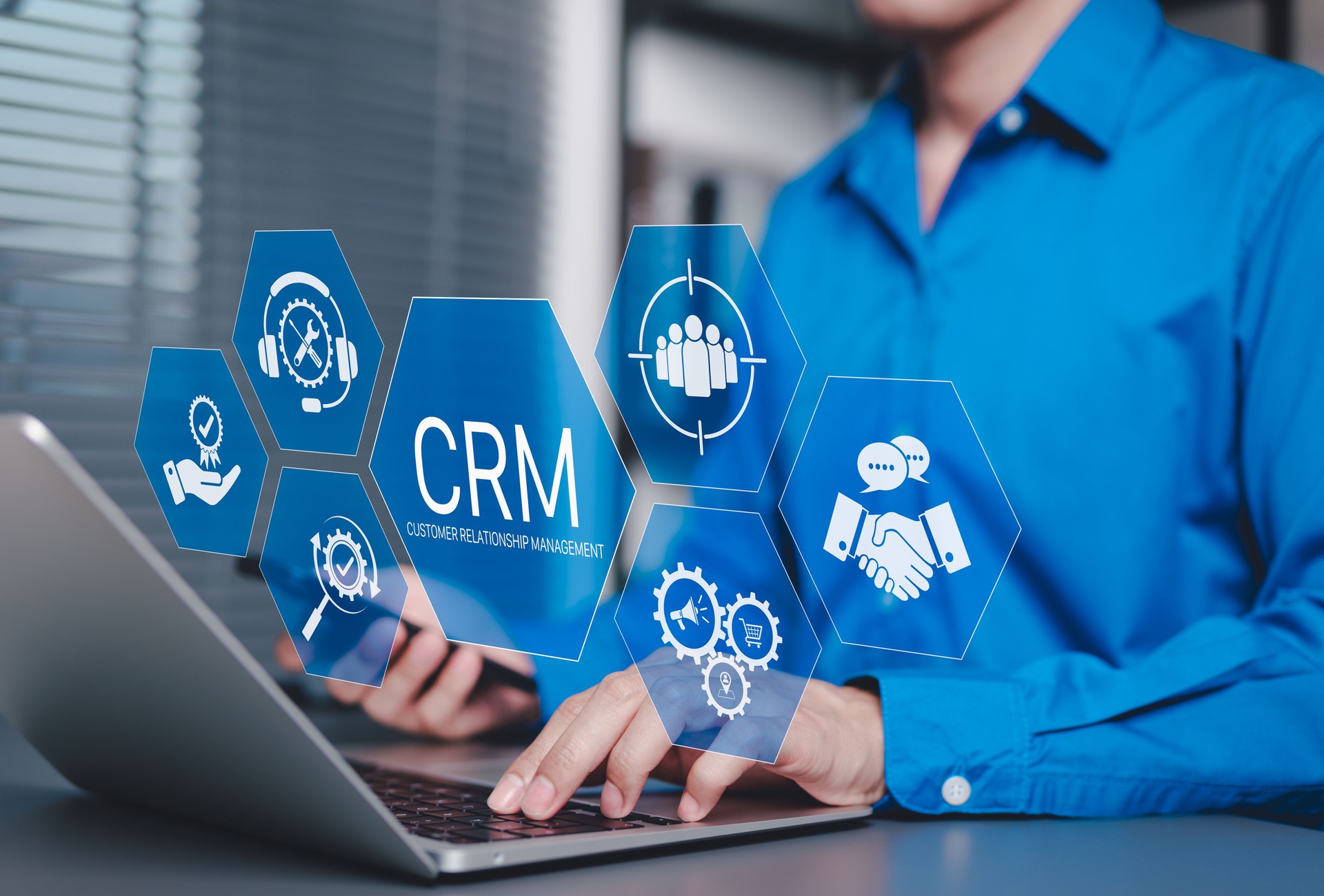 CRM Customer Relationship Management Concept. Businessman using laptop with CRM icons representing customer support, service, relationship building, sales, and marketing automation tools software.