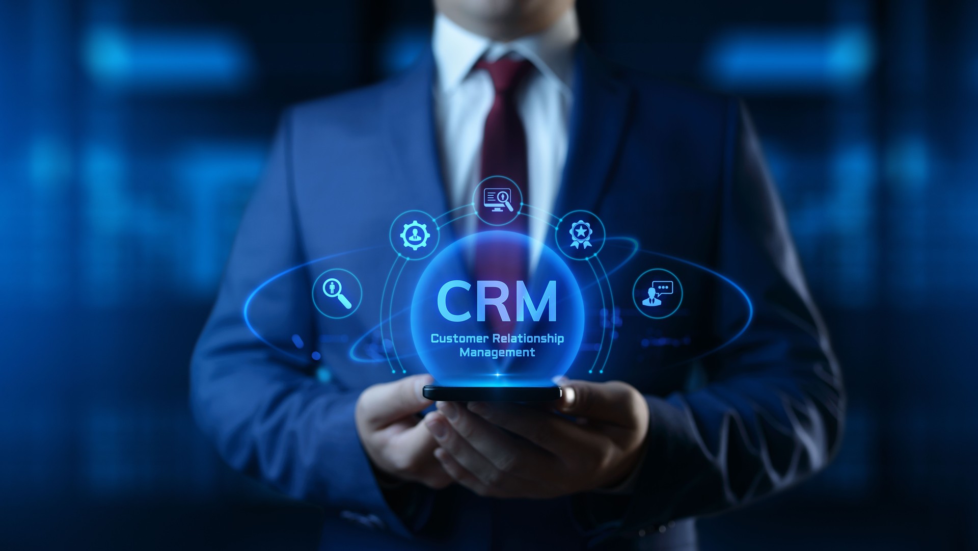 Businessman holding smartphone with CRM Customer Relationship Management icons on screen